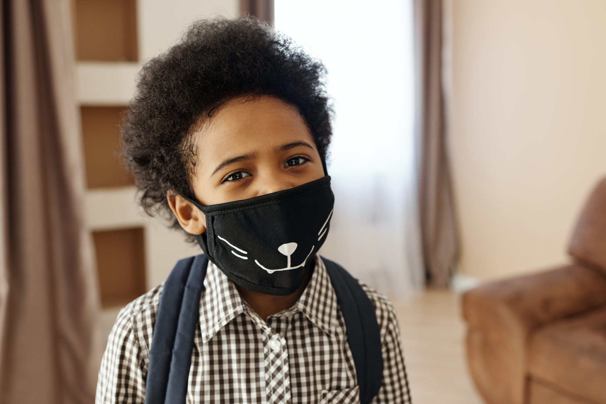 Young boy wearing a mask to protect against coronavirus and emerging Multisystem Inflammatory Syndrome in Children
